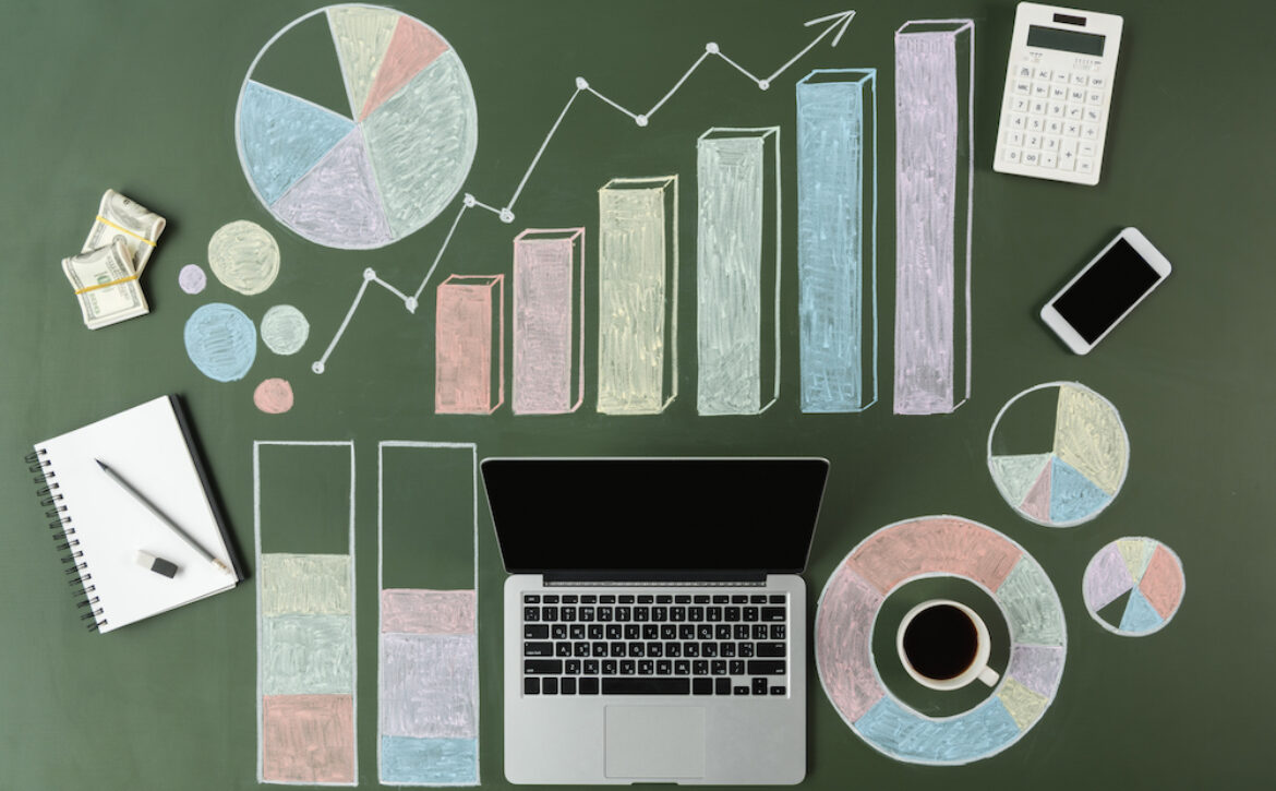 top view of laptop and business charts with cup of coffee and smartphone, laptop computer
