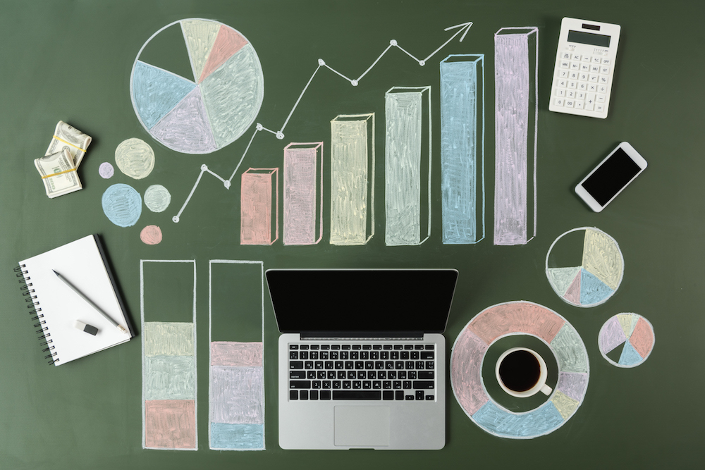 top view of laptop and business charts with cup of coffee and smartphone, laptop computer